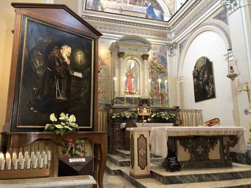 Pittura sacra all'interno di una chiesa storica con altare decorato e affreschi dettagliati, atmosfera di spiritualità e arte religiosa.