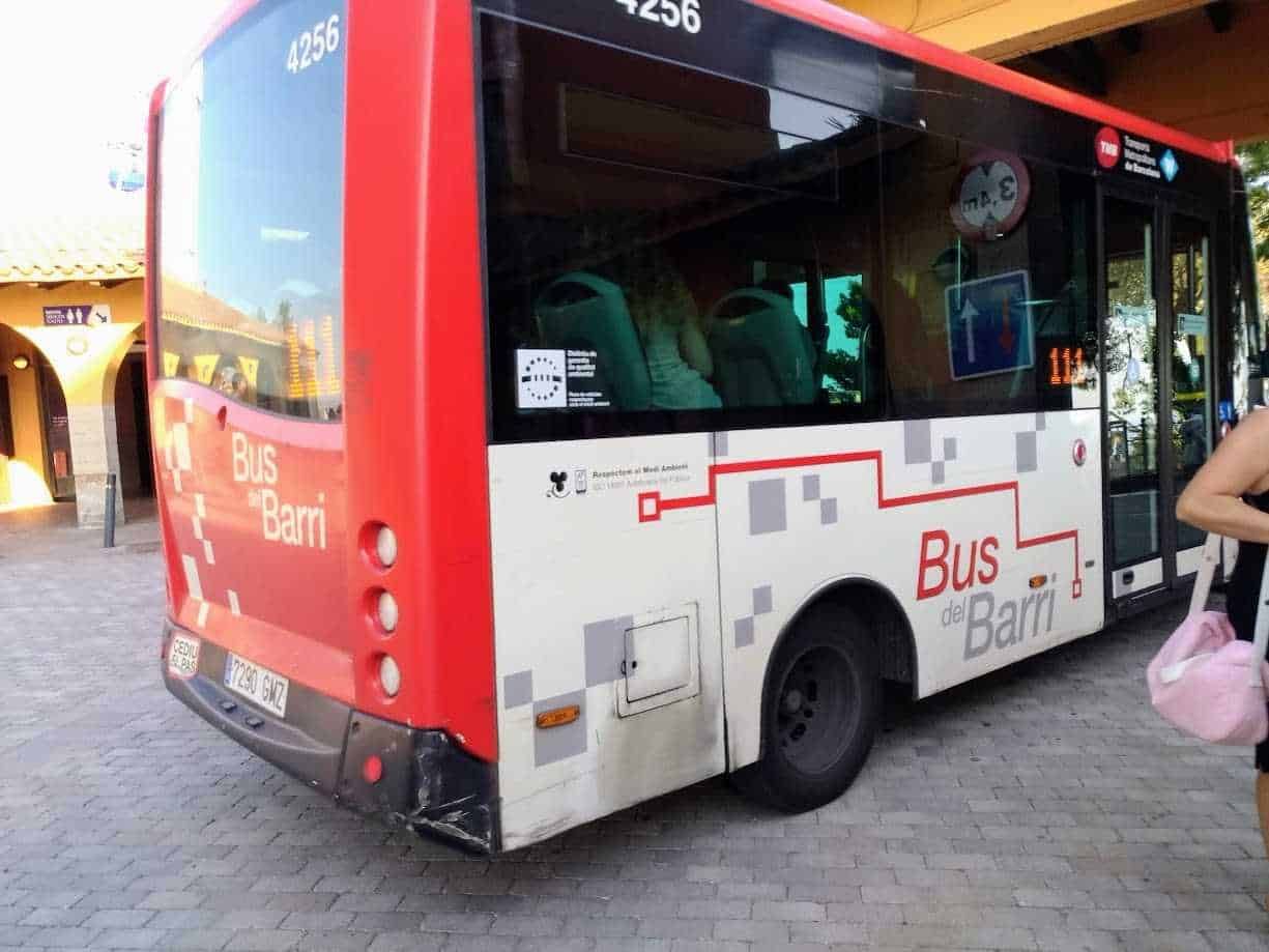 Autobus rosso e bianco con logo "Bus del Barri" a Madrid, arredamento urbano, servizio di trasporto pubblico.