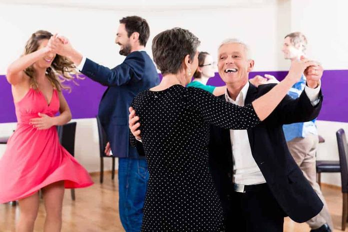 La Danza Oggi: dalle Scuole ai Palcoscenici Internazionali 5 Spettacolare scena di persone anziane e giovani che ballano insieme in un ambiente colorato, che trasmette gioia e condivisione in un momento di festa.