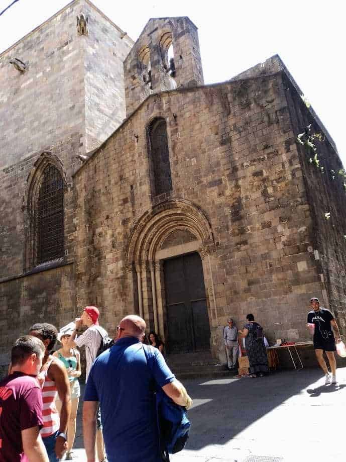 La cattedrale di Barcellona si chiama Santa Eulalia 2 Antica chiesa di pietra con archi e vetrate, scenario di turisti e visitatori davanti all'ingresso in un centro storico.