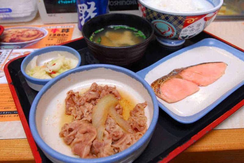 Tour Japan Golden Route in 10 giorni 7 Sazuke di pesce e carne con riso e zuppa miso, tipico pasto giapponese. Menu di cucina giapponese con piatti tradizionali, alimenti tipici e una presentazione autentica in stile giapponese.