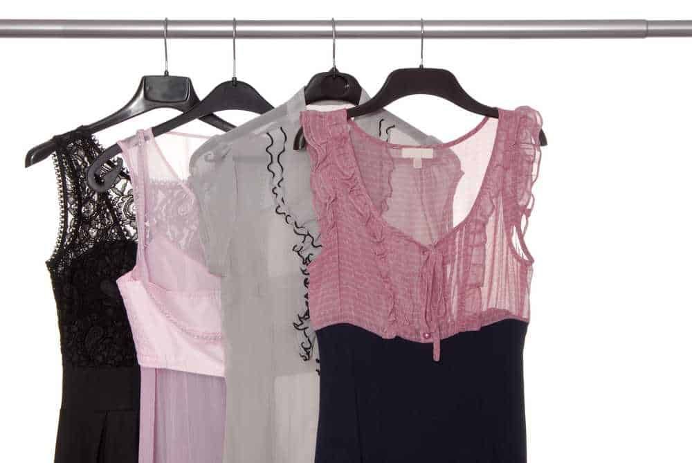 Vestiti eleganti e casual femminili con dettagli in pizzo e tessuti leggeri, appesi su una gruccia per mostrare lo stile e la moda estiva e invernale, perfetti per occasioni diverse.
