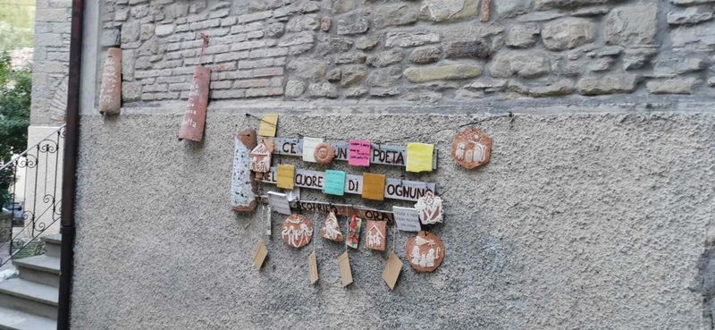 Portico di Romagna il paese di Dante e Beatrice 4 Creativa decorazione su parete con citazioni e ornamenti artigianali in terracotta, proveniente da Appunti Sul Blog, perfetta per ispirare poesia e creatività all'aperto.