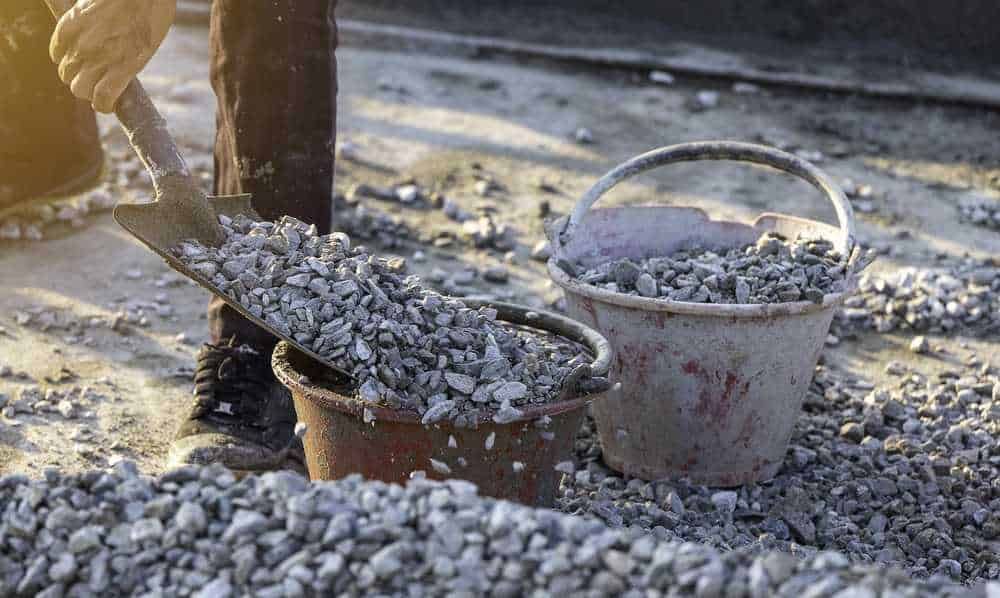Cemento romano: Sabbia e ghiaia per lavori di costruzione, con secchi e paletta su un cantiere all'aperto in fase di preparazione del sito.