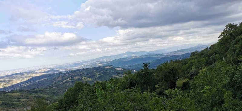 Cosa vedere a Guardiagrele e dintorni Abruzzo 12 Paesaggio collinare verde con montagne lontane e cielo nuvoloso, vista panoramica delle colline toscane, ideale per articoli di viaggio e natura su Appunti Sul Blog.