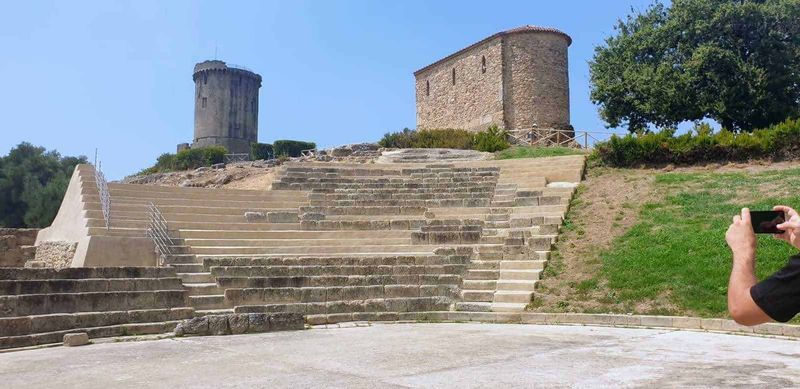 Scavi di Velia Paestum cosa vedere in 2 ore 2 Velia e paestum: Antica struttura con scalinate in pietra e torri medievali su un prato verde, sito archeologico storico in Italia.