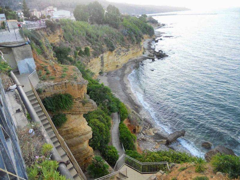Castellammare del Golfo attrazioni e dintorni 7 Scogliera con sentiero panoramico e vista sul mare, paradiso naturale sull'Adriatico con piante verdi e roccia arenaria.