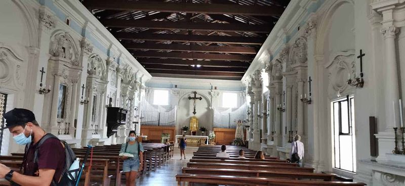 Cosa vedere a Guardiagrele e dintorni Abruzzo 8 Immagine di una chiesa storica con pareti ornate, altare centrale e persone con mascherina. Interno di un luogo di culto con architettura barocca, atmosfera di spiritualità e arte religiosa, visitatori che esplorano lo spazio sacro.