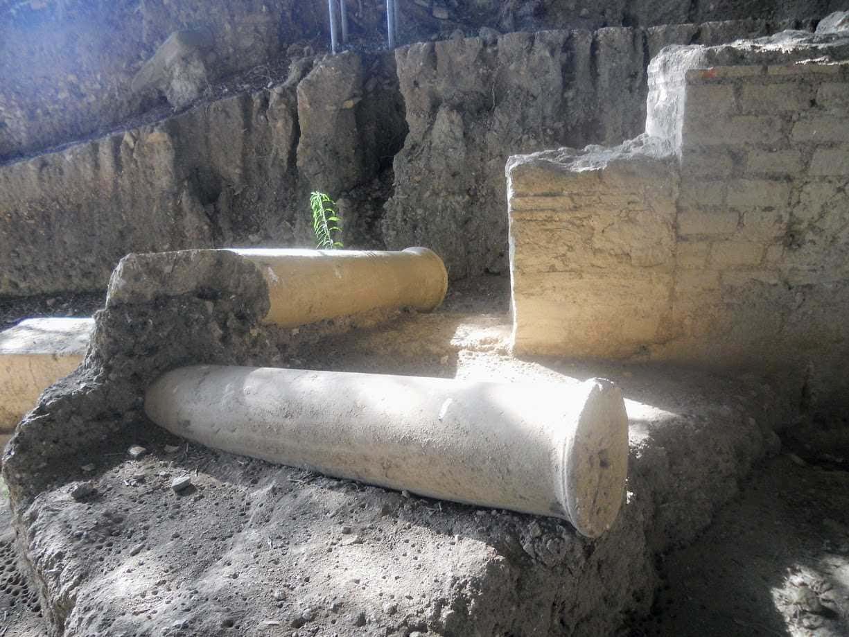 Vecchi resti di strutture archeologiche o ruderi di antiche costruzioni in pietra e mattoni, scoperti durante scavi o scoperte storiche, con luci e ombre naturali.