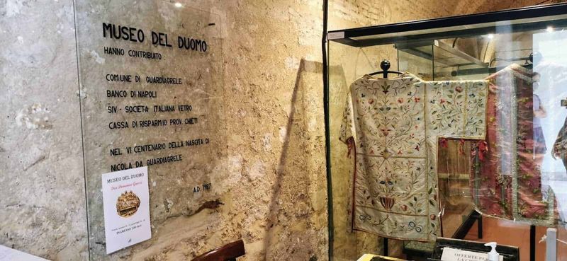 Cosa vedere a Guardiagrele e dintorni Abruzzo 9 Antico vestito ricamato esposto nel Museo del Duomo a Napoli, simbolo di arte e storia religiosa, con testimonianze di contributi storici e culturali.