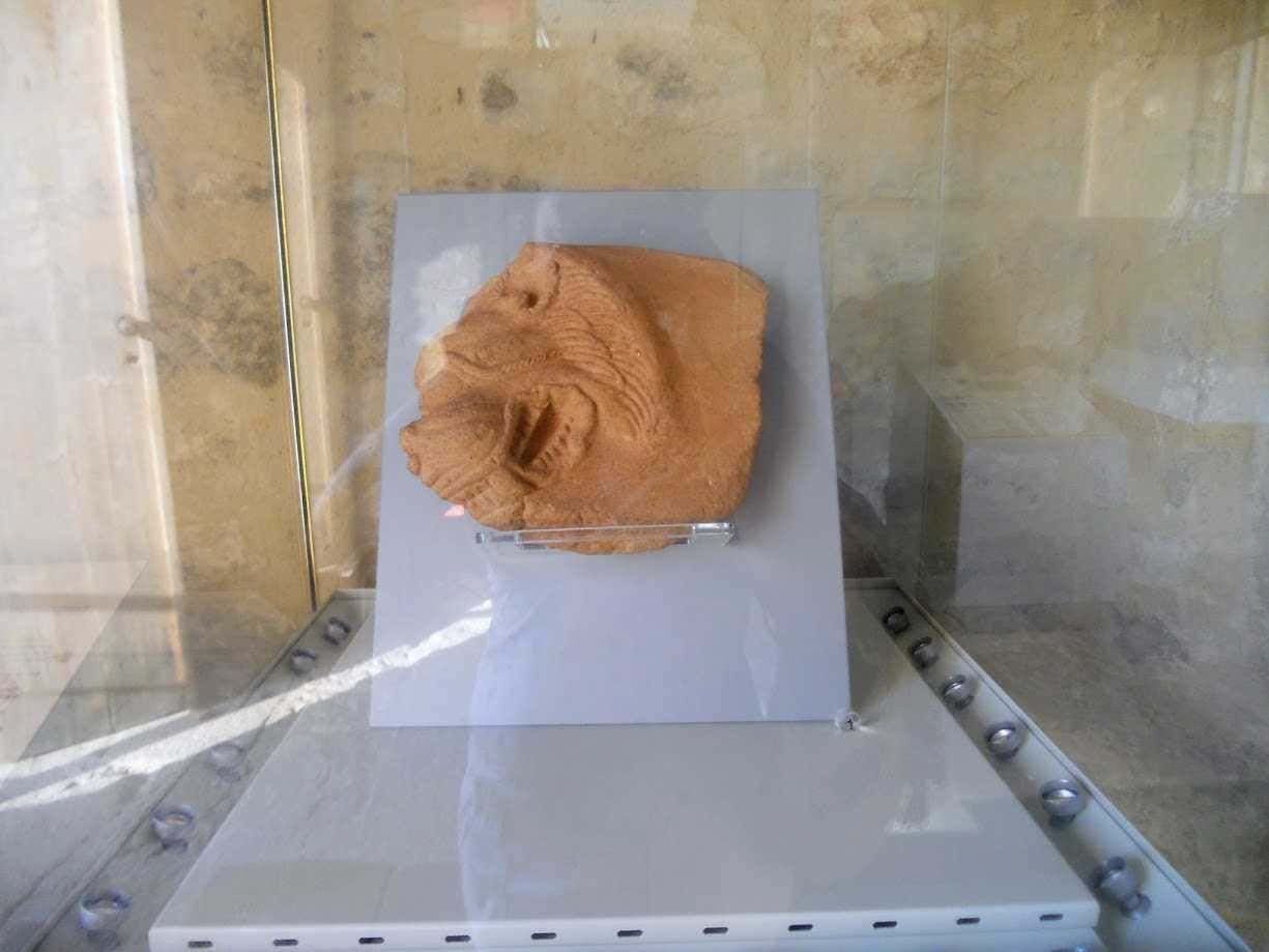 Tecnica di scultura in pietra raffigurante un leone maestoso, esposta in mostra museale con illuminazione mirata e ambiente di architettura moderna. Perfetta per appassionati di arte e sculture storiche.