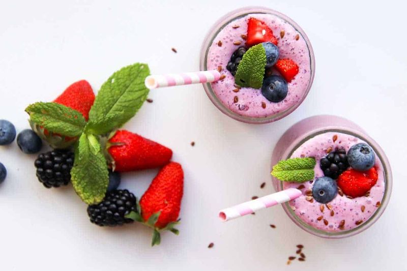 Ritrova la tua energia: guida al benessere per la primavera 2 Benessere di primavera: Fragola, mirtillo e lampone in frullati decorati con menta e semi di lino, perfetti per una merenda sana e rinfrescante alta qualità.