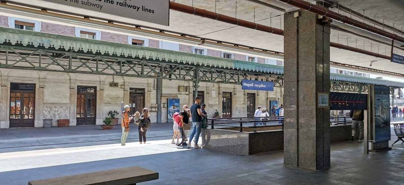 Stazione treni Mergellina a Napoli 10 Stazione Napoli Mergellina, persone in attesa del treno sulla piattaforma ferroviaria, atmosfera urbana, viaggiatori con bagagli, dettagli architettonici, ambiente di trasporto pubblico.