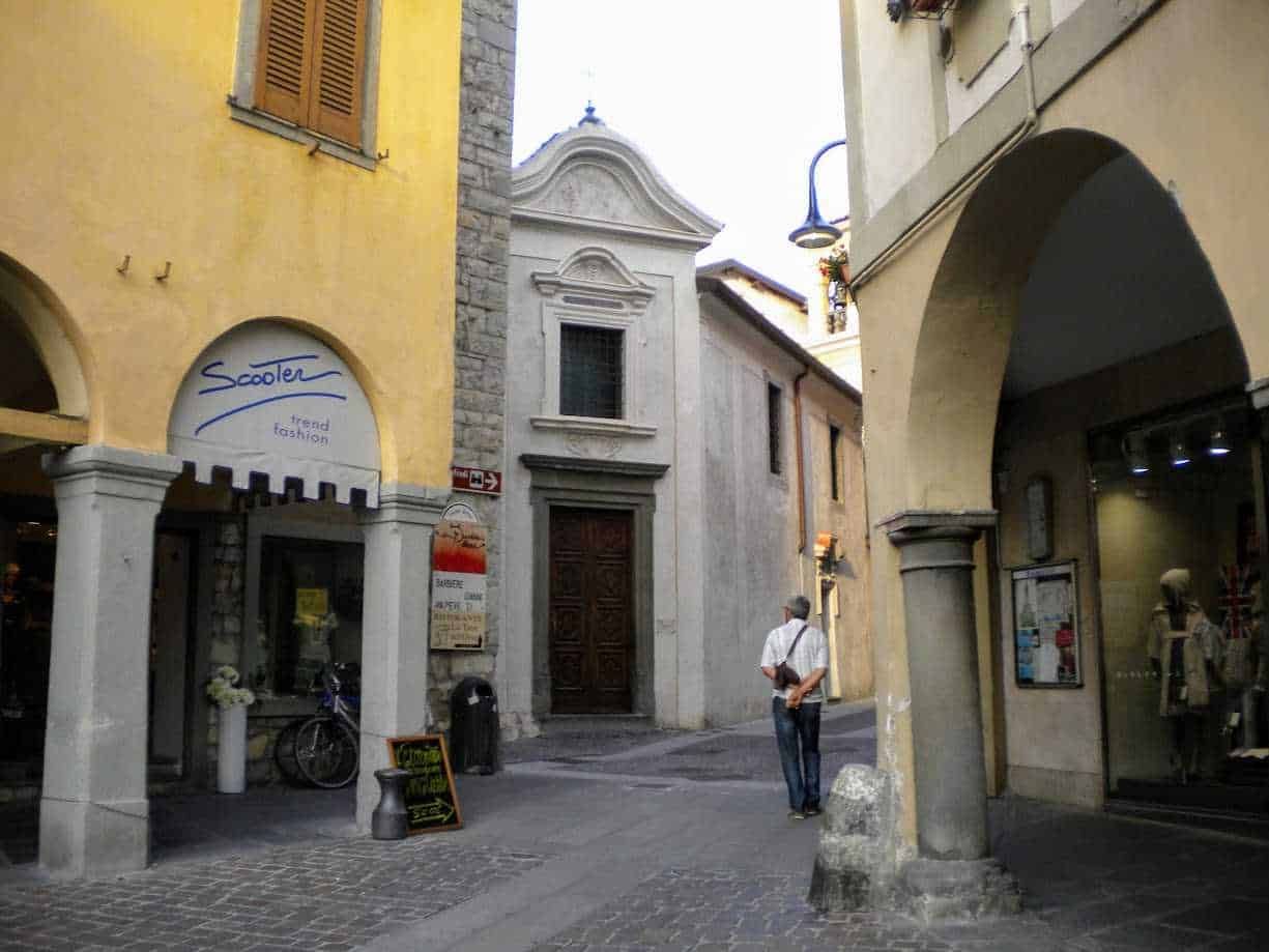 Antico vicolo nel centro storico di Iseo, case colorate e negozi con luci calde, atmosfera tipica italiana, e strada pedonale con edifici in stile veneto.