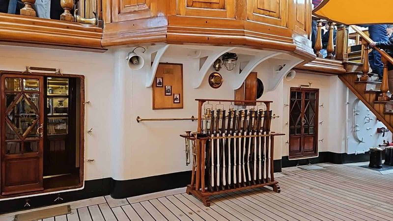 Amerigo Vespucci a Napoli 2025: cosa sapere 19 Elegante interni con elementi in legno, focus su scaffale con bottiglie, ambientazione accogliente e raffinatamente decorata.