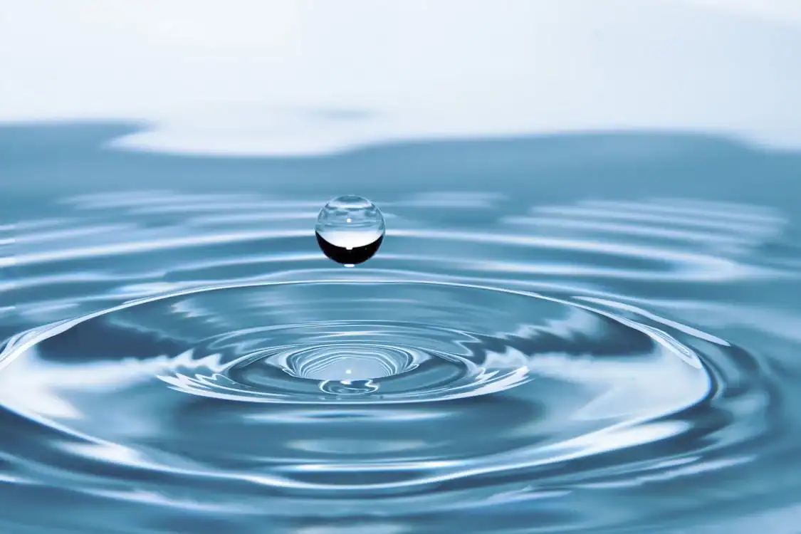 Acqua pura, salute sicura: perché scegliere un depuratore d'acqua per la tua casa 2 Goccia d'acqua che cade e crea cerchi concentrici sull'acqua, simbolo di fluidità e precisione nel potere dell'acqua naturale, ideale per contenuti sul blog come natura, scienza e benessere.