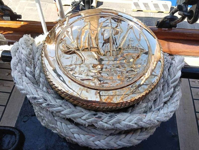 Amerigo Vespucci a Napoli 2025: cosa sapere 15 Vassoio in cristallo con nave su strada, decorazione dettagliata in rilievo, posizionato su corda di canapa intrecciata, luce naturale e sfondo urbano.