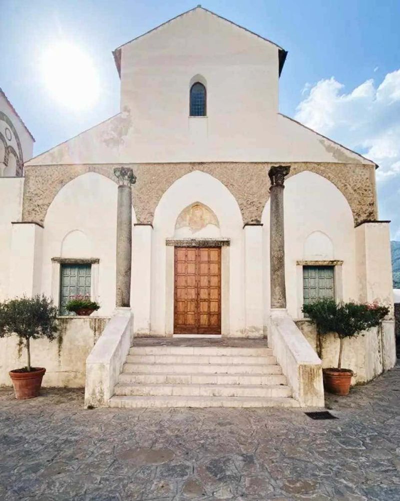 Stili dei portoni a Ravello: dal Medioevo al rustico 5 Elegante porta in legno massello con dettagli nella parte superiore e maniglione in ottone, ideale per l'ingresso di una casa moderna o tradizionale.
