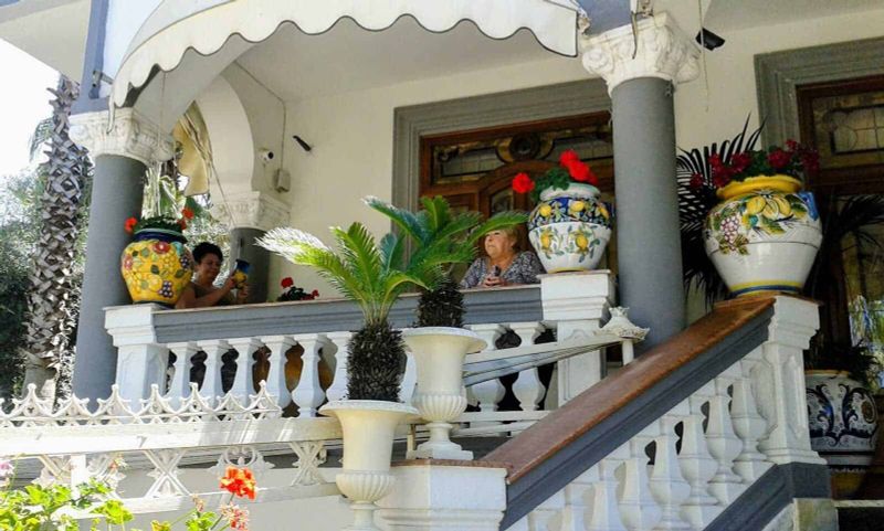 Cosa piantare a luglio sul balcone: guida pratica per un angolo verde anche in estate Fiorita veranda con piante e vasi di Ceramica dipinti a mano, decorata con colonne e ringhiere eleganti, ideale per relax e incontri estivi.