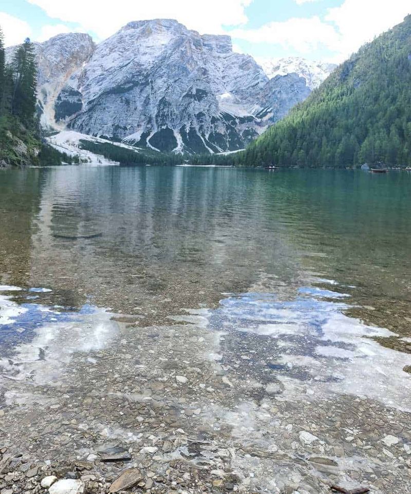 Cosa aspettarsi al Lago di Braies in inverno 3 Montagne innevate e lago cristallino con sponde rocciose, paesaggio naturale di grande bellezza in Dolomiti, Italia, perfetto per appassionati di escursionismo e fotografia.