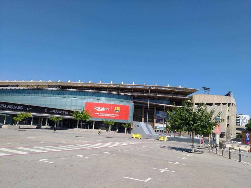 Montjuïc Barcellona cosa vedere in 1 giorno 4 Stadio Camp Nou di Barcellona, arena principale del FC Barcelona, moderna ed imponente, con cielo sereno e parcheggio vuoto in prima piano.