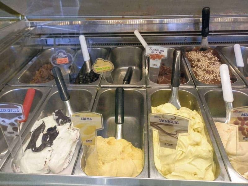 Gelateria a Milano: come scegliere quella ideale 5 Ampio banco di gelato artigianale con gusti come crema, vaniglia, cioccolato al latte e altre varietà, servito in una gelateria italiana. Disponibili anche gusti con topping e aromi variegati.