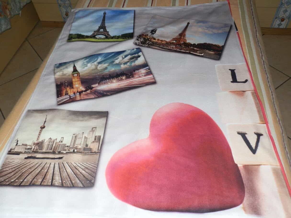 Panorami di Parigi con immagini del Torre Eiffel e Big Ben, decorazioni romantiche con un grande cuore rosso su un tessuto con lettere L e V, ideale per contenuti di viaggi e amore.