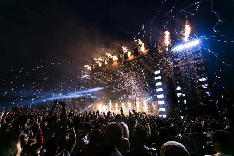 Ferragosto come si festeggia in Italia 4 Festa di musica dal vivo con fuochi d'artificio, luci e pubblico entusiasta che si diverte a un concerto notturno, atmosfera di festa e emozione vibrante.