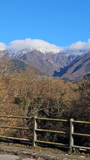 Montagne innevate e paesaggio naturale con cielo azzurro e nubi bianche, perfetto per articoli su viaggi e natura.