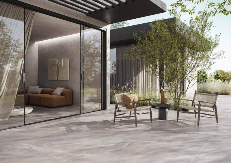 Come scegliere le piastrelle da giardino 7 Moderno patio esterno con sedie di legno e giardino, vista sulla natura, design minimalista e arredamento elegante in stile contemporaneo. Perfetto per relax e incontri all'aperto.