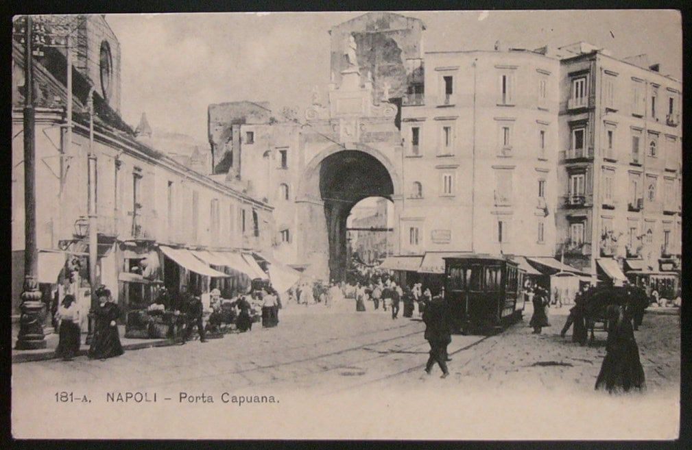 Antica immagine di Napoli con Porta Capuana, scena di vita quotidiana, tram e negozi, rappresentazione storica del 19° secolo, atmosfere di epoca passata, patrimonio culturale partenopeo.