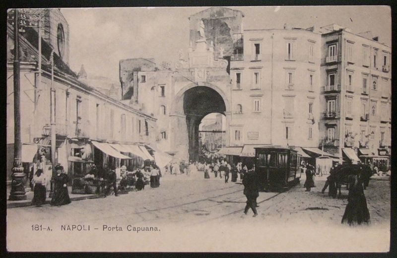 Dove si trova Porta Capuana a Napoli: Storia e come arrivare 3 Antica immagine di Napoli con Porta Capuana, scena di vita quotidiana, tram e negozi, rappresentazione storica del 19° secolo, atmosfere di epoca passata, patrimonio culturale partenopeo.