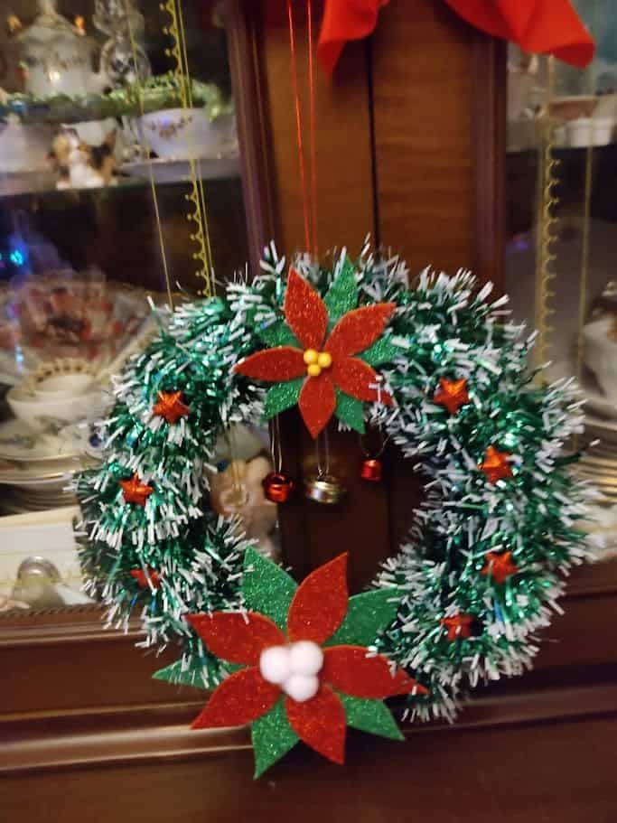 Ghirlanda natalizia decorazioni per porte 4 Corona di Natale decorata con fiori di poinsettia, pigne e stelle di tessuto verde e rosso, perfetta per addobbare la porta o la casa durante le festività natalizie.