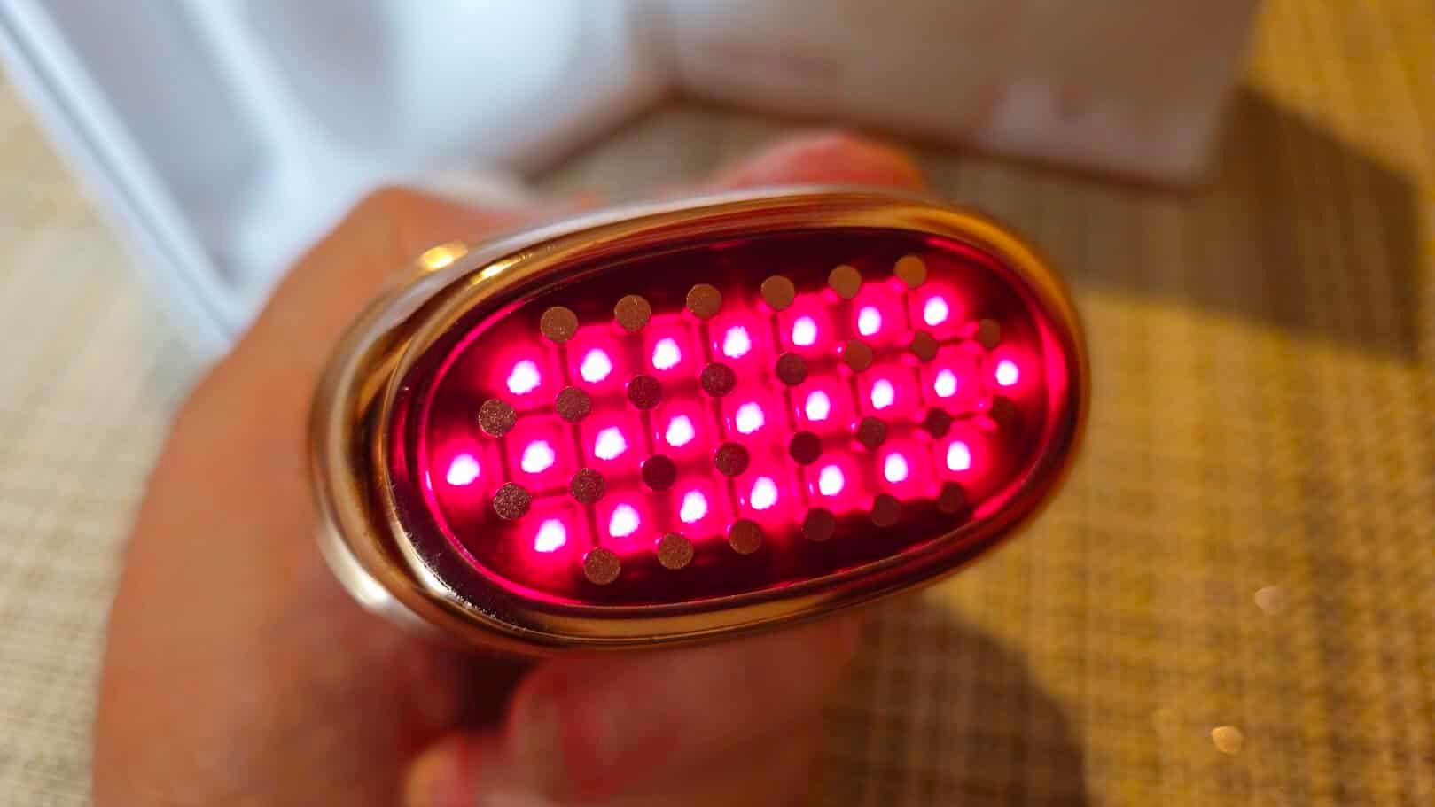 Pulsante LED rosso acceso con luci luminose, utilizzato per segnalare stato o funzione in dispositivi elettronici.