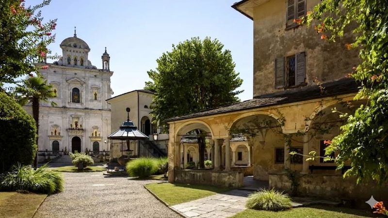 8 attrazioni a Varallo e dintorni in Valsesia 3 Un'immagine di un antico edificio e una chiesa storica nel centro di Milano, circondati da alberi e un giardino ben curato, con un'atmosfera tranquilla e suggestiva.