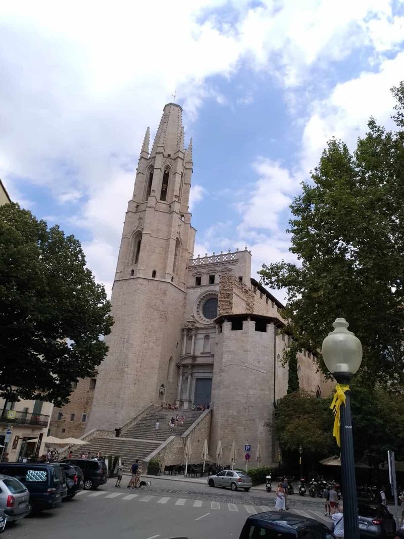 Impressionante vista della chiesa di Sant'Antonio a Maiorca con la sua torre alta e dettagli architettonici storici, circondata da alberi e un cielo nuvoloso.