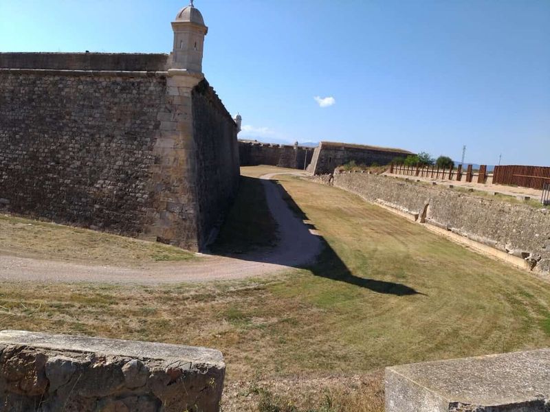 Castello di Sant Ferran a Figueres: la fortezza più grande d'Europa (Orari, Prezzi e Sotterranei) 4 Immagine di un'antica fortificazione con mura di pietra e torre di avvistamento sotto un cielo sereno.
