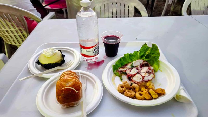 Festa Limoni Dragonea 2026: menù, come arrivare 5 Piatti tradizionali e bevande su tavolo all'aperto, con insalata di polpo, pane, acqua e vino rosso