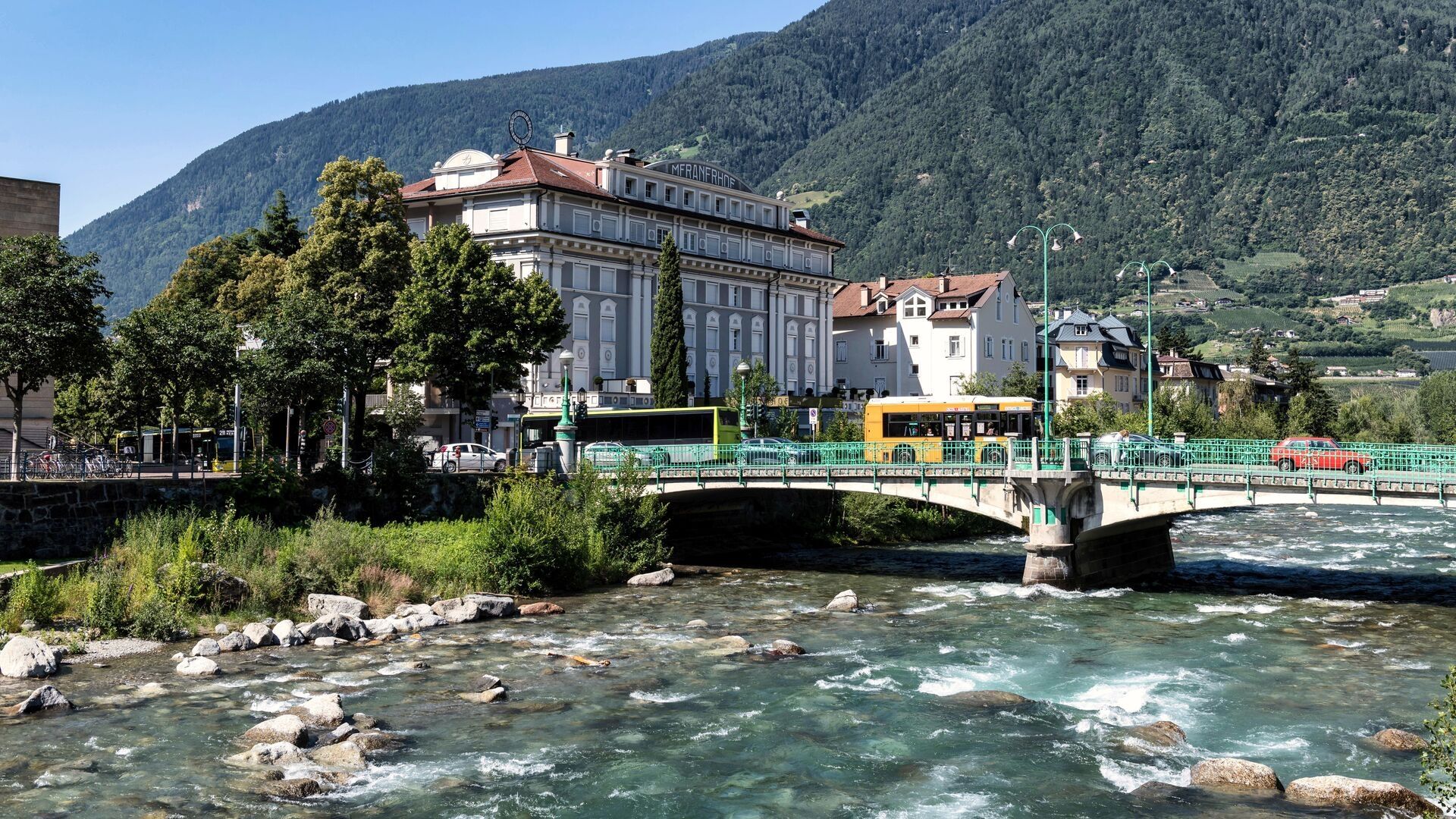 lungofiume di Merano, che mette in mostra l'architettura storica e lo splendido scenario montano sullo sfondo