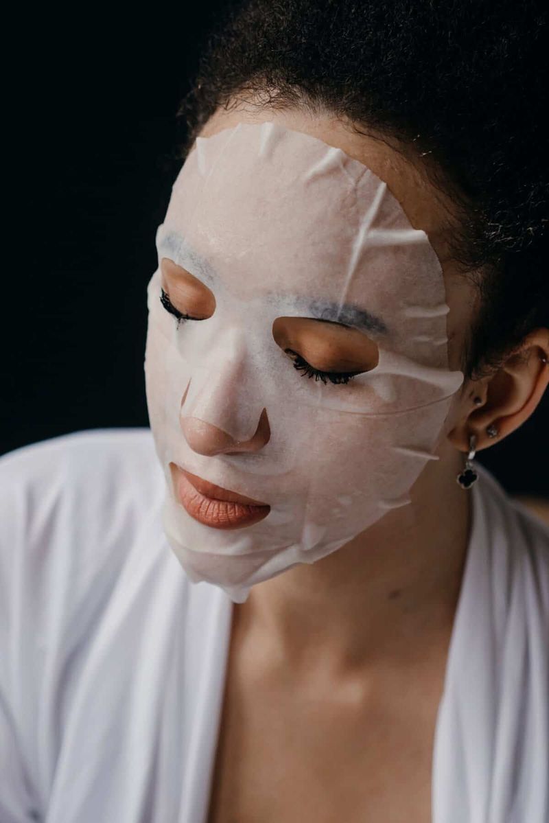Maschera notte o maschera in tessuto: differenze e quale scegliere 2 Maschera notte o maschera in tessuto: Close-up di una donna che usa una maschera idratante per la routine di cura della pelle, promuovendo la cura del viso a casa
