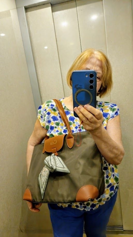 Outfit con borsa verde Callie, jeans e maglia colorata