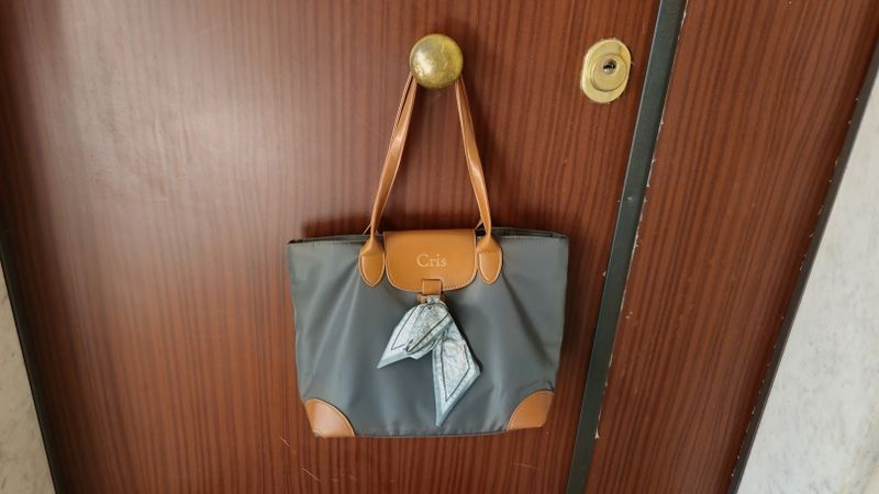 Borsa verde in tela Callie con nome 2 Borsa verde Callie appesa al pomello della porta di ingresso