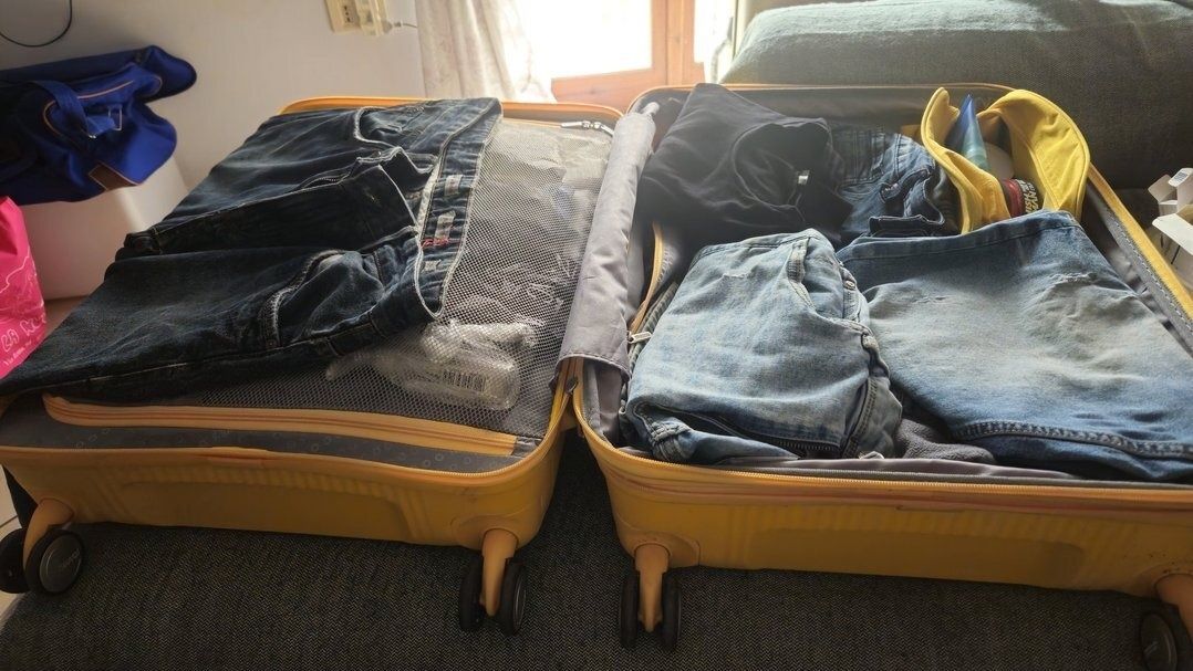 Borsa da viaggio gialla aperta in camera - come scegliere borsa da viaggio con rete e cinghie