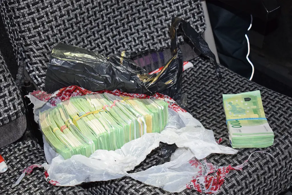 Пачки с наличными евро в разорванном пакете на сиденье