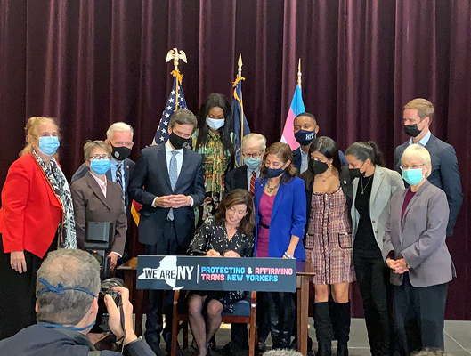 Governor Hochul Signs the Survivors of Trafficking Attaining Relief Together (START) Act surrounded by the bill’s sponsors and advocates. (NYATN, 2021)