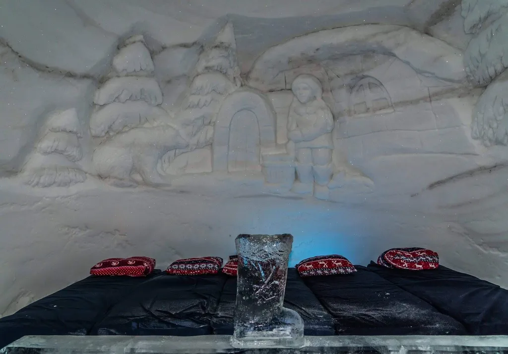 ice hotel room with sculpture and beds