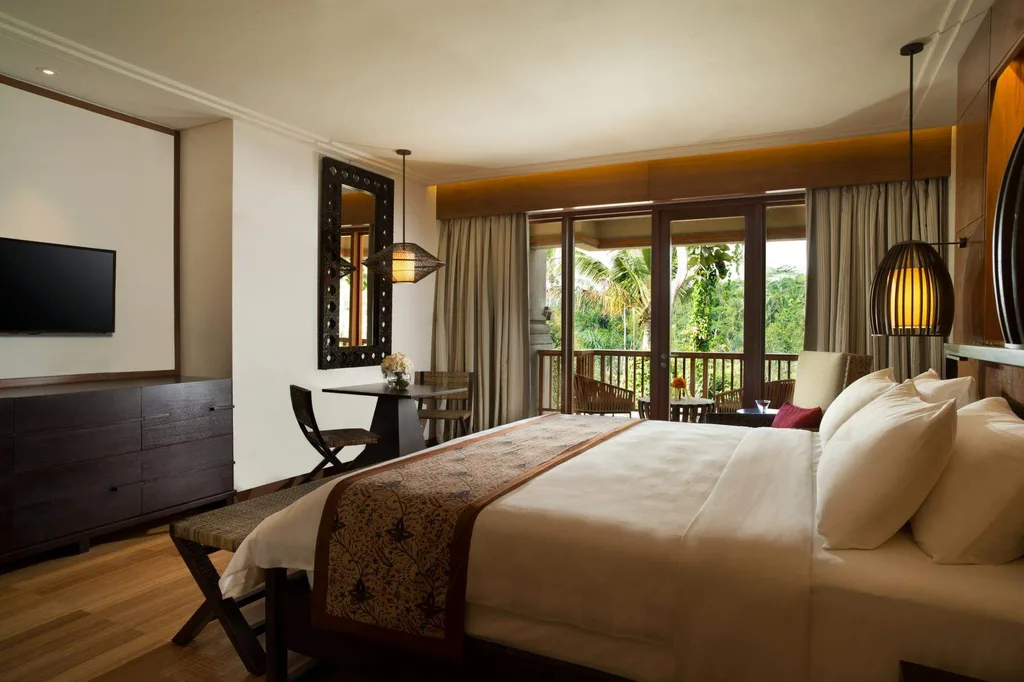 resort bed with large sliding glass window overlooking forest