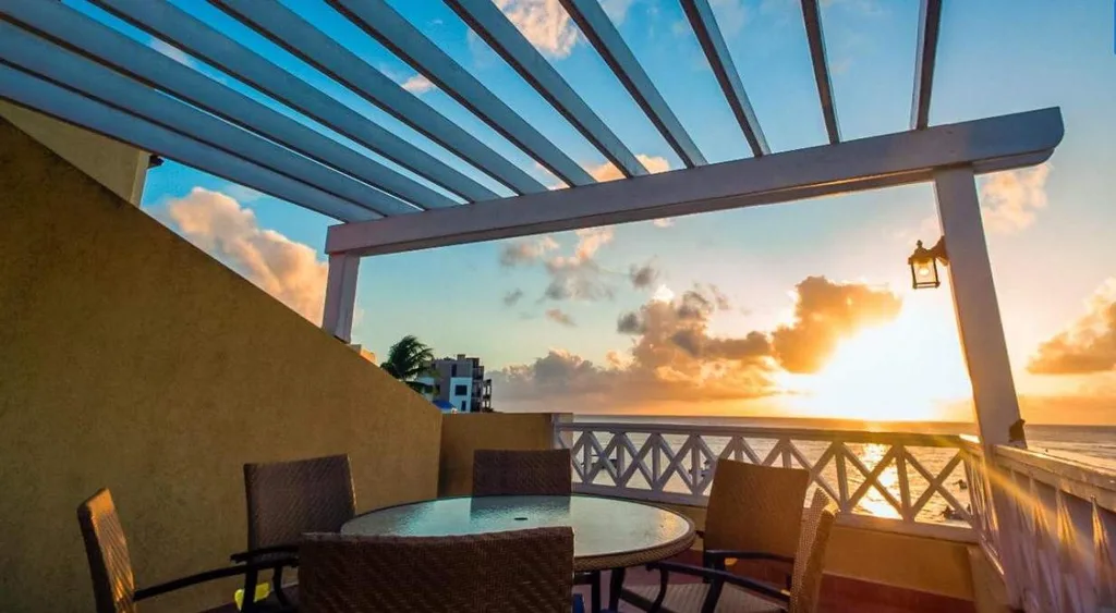 table and chairs under portico at sunset