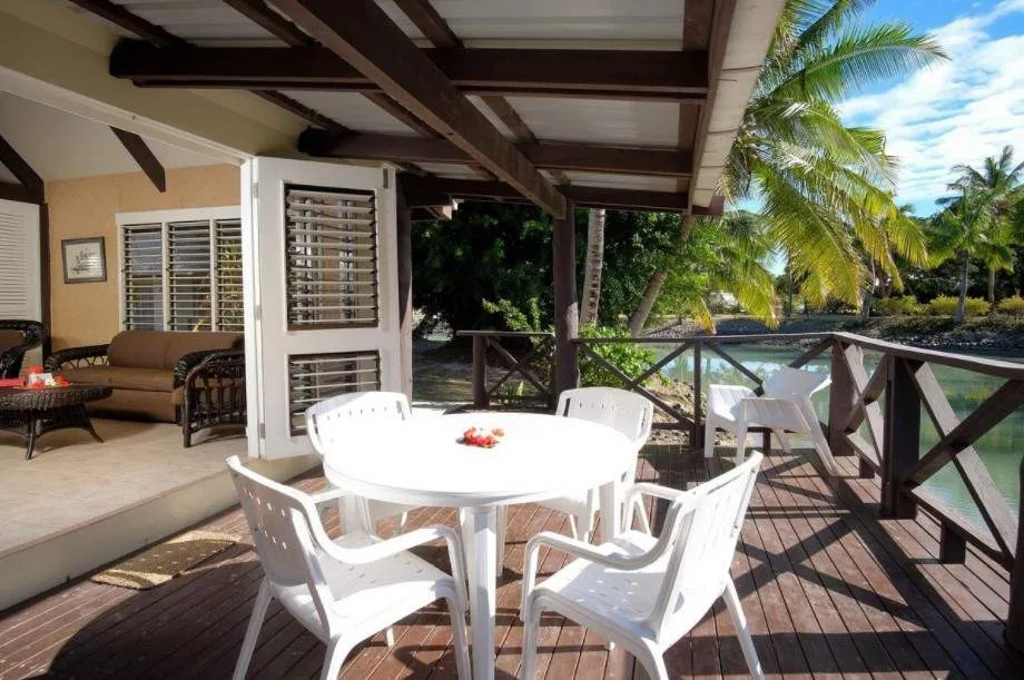 white table and chairs on deck surrounded by forest