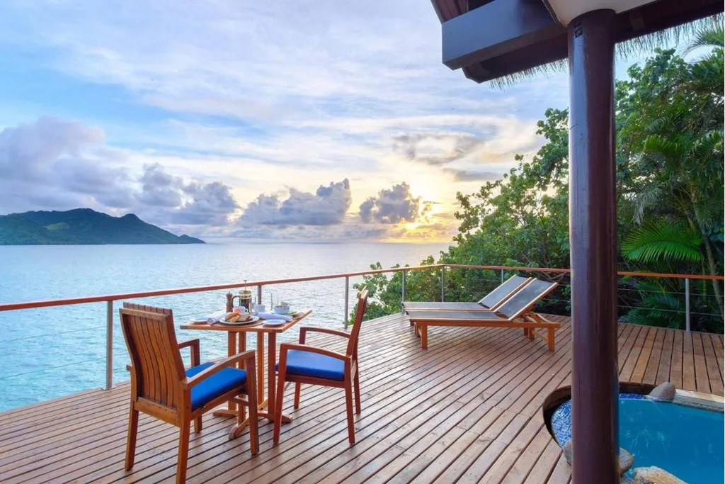 chairs table and lawn chair on deck overlooking water